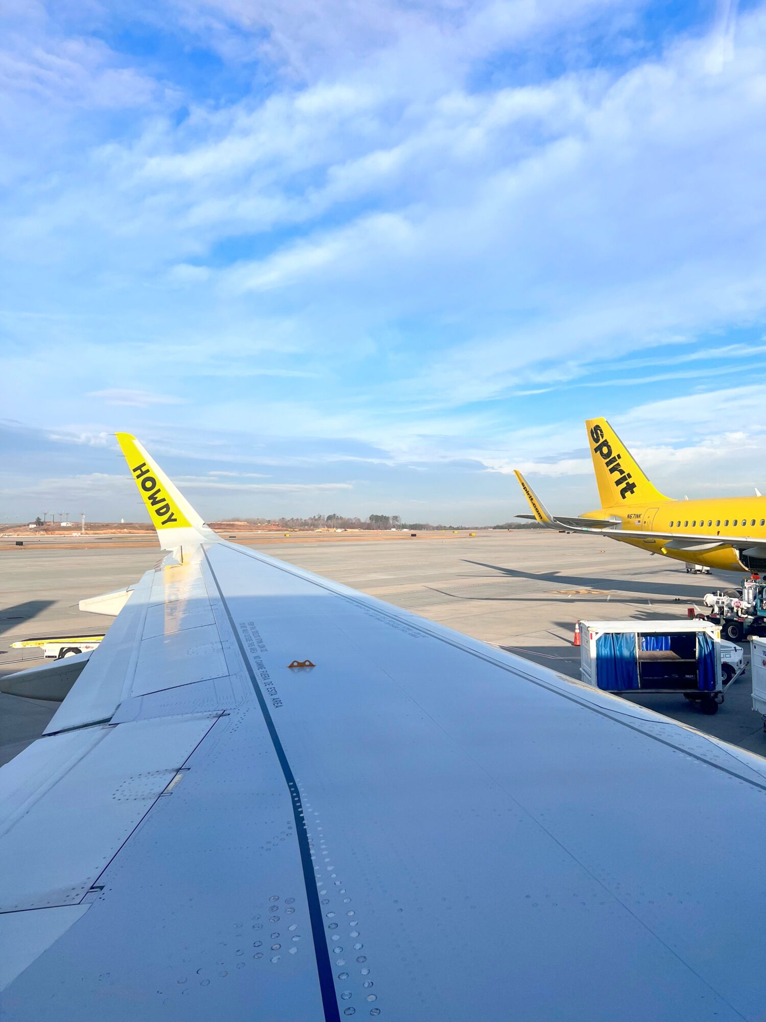 15 Essential Tips for First-Time Flyers with Spirit Airlines A Spirit airplane wing that reads 'HOWDY'
