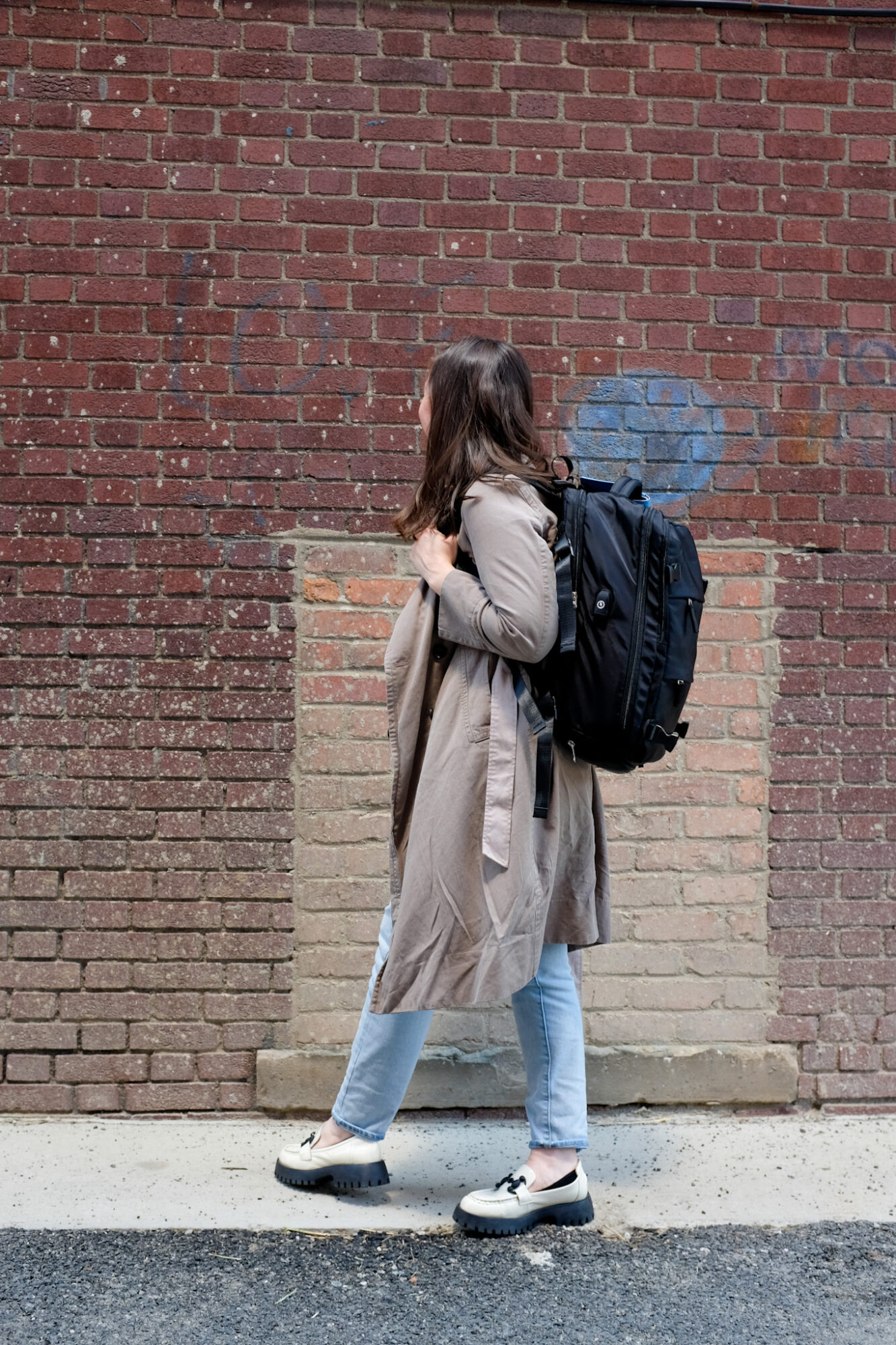 15 Essential Tips for First-Time Flyers with Spirit Airlines Alyssa wears a tan trench and carries a black backpack that fits Spirit Airlines' personal item dimensions